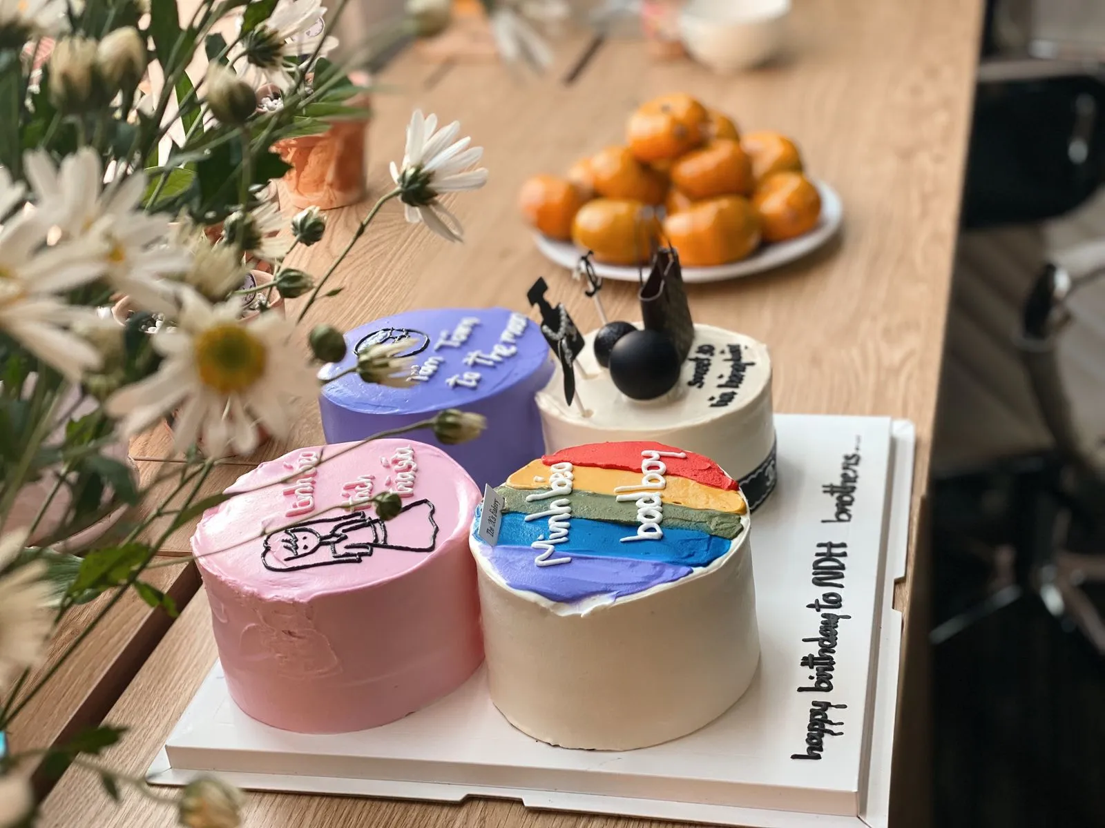 Trois bento cakes décorés posés sur leurs boîtes en carton